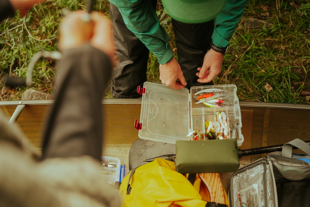 a man standing over a table filled with lots of items