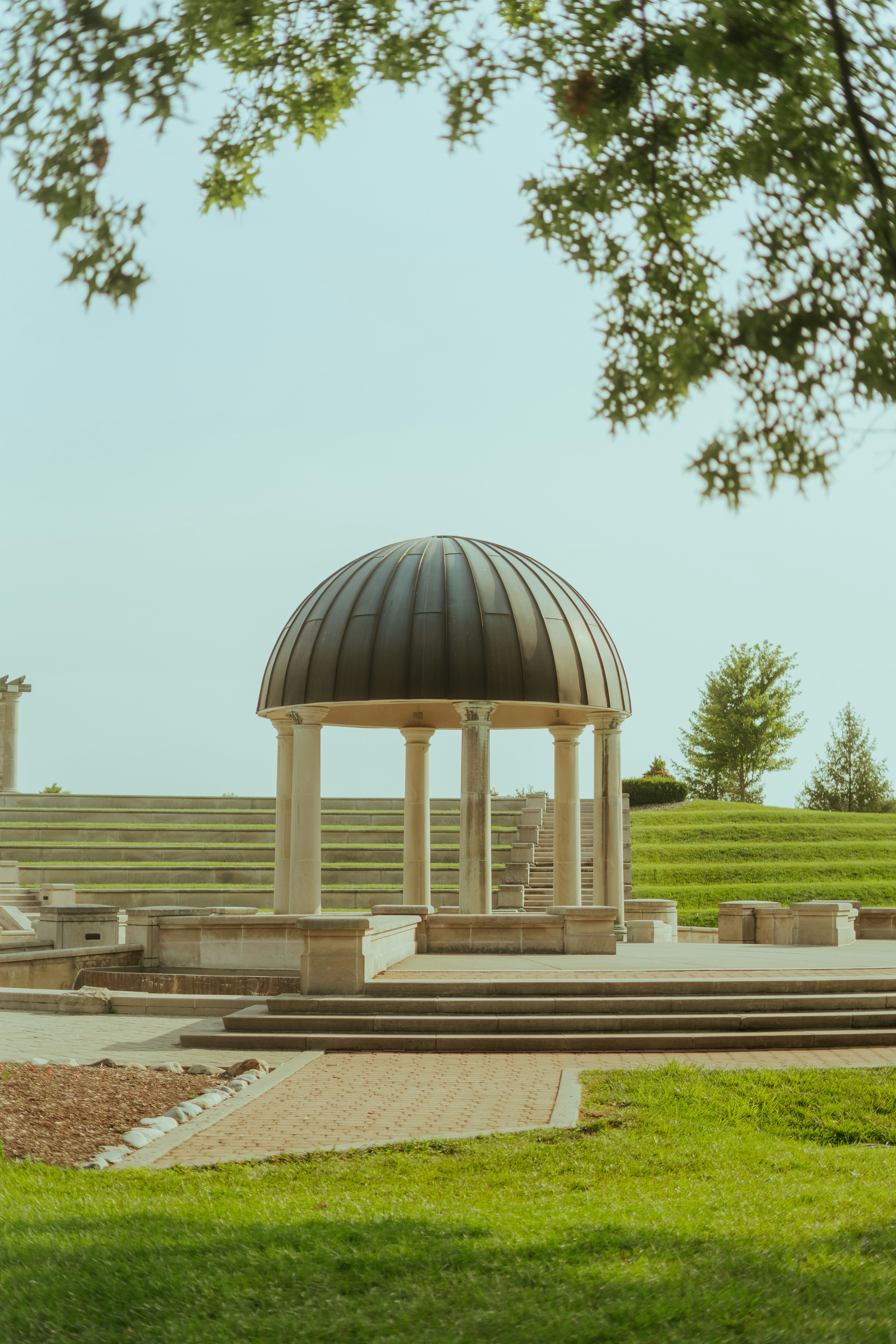 a gazebo sits in the middle of a grassy area