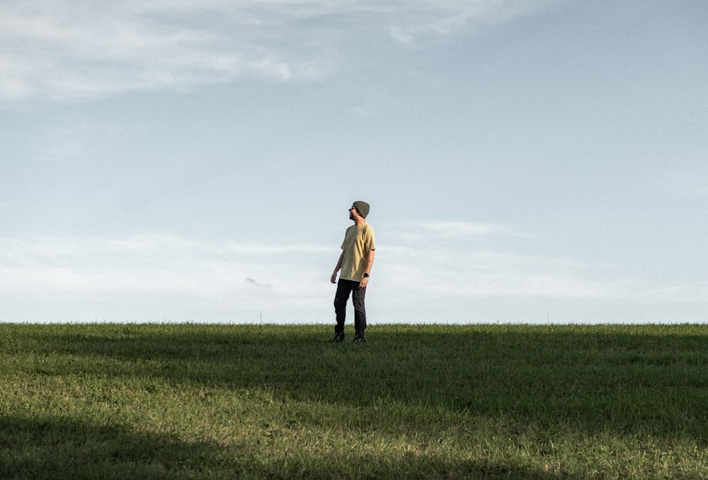 a man standing on top of a lush green field