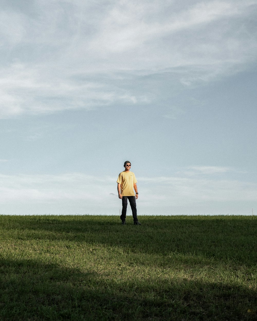 a man standing on top of a lush green field