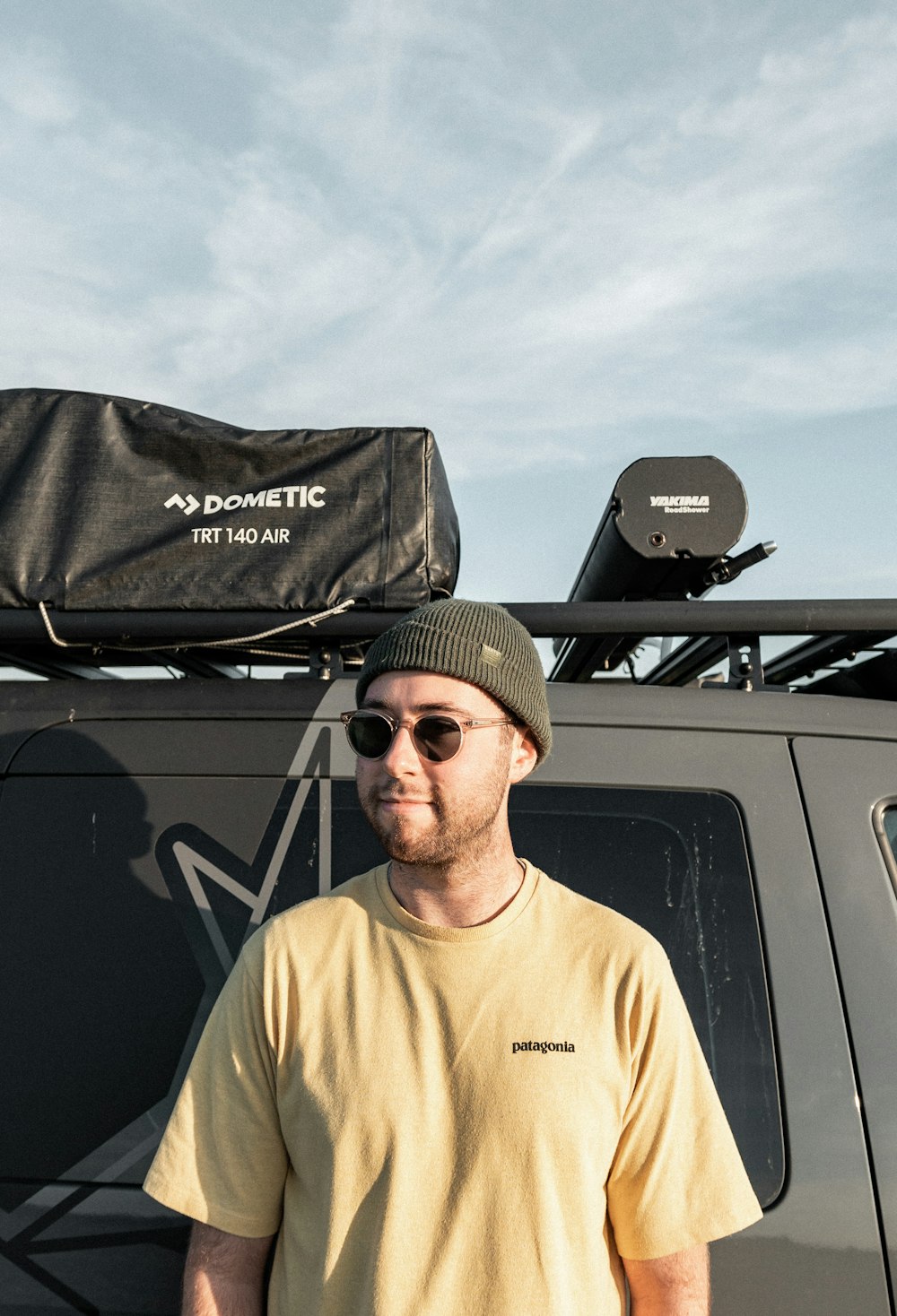 a man standing in front of a truck with a bag on top of it