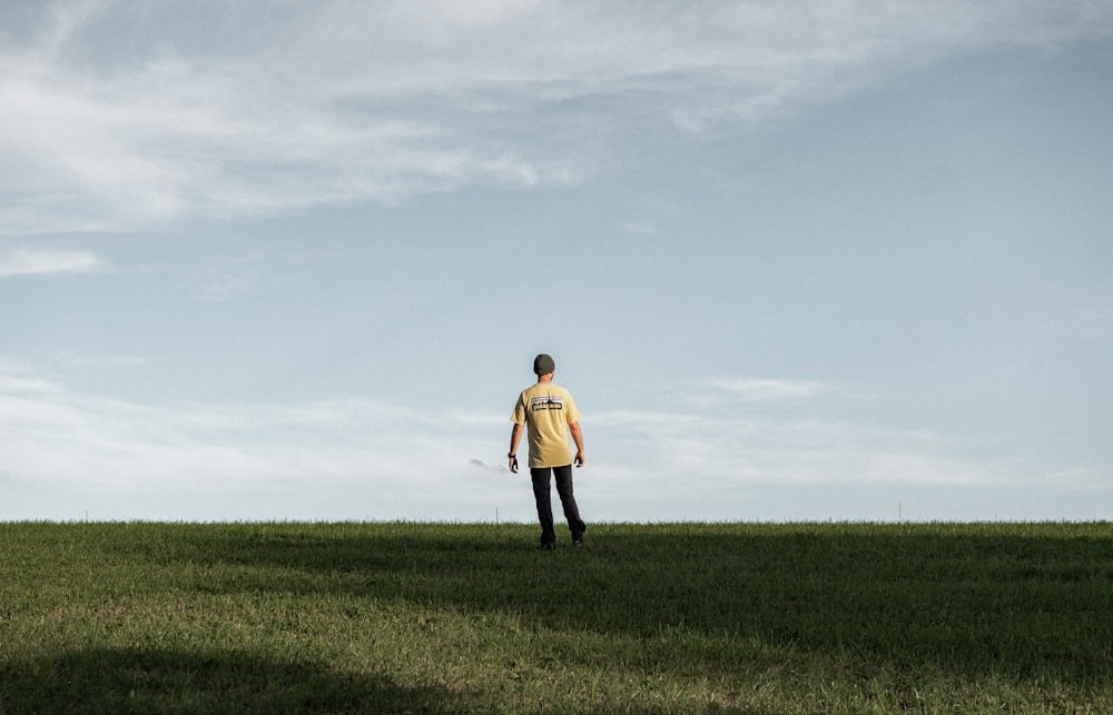 a person standing in a field with a kite