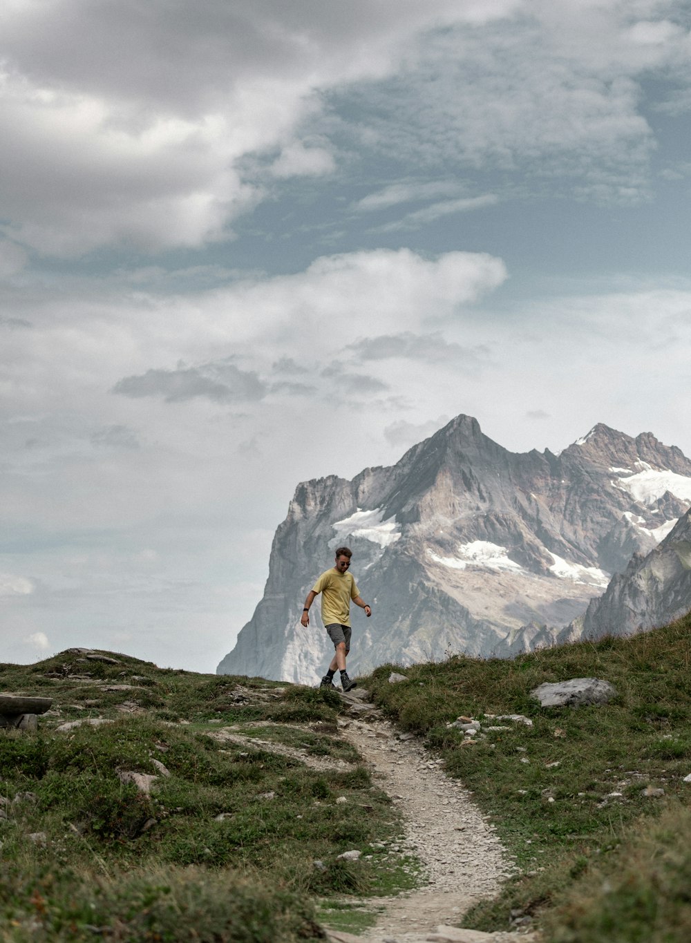 a man hiking up a trail in the mountains