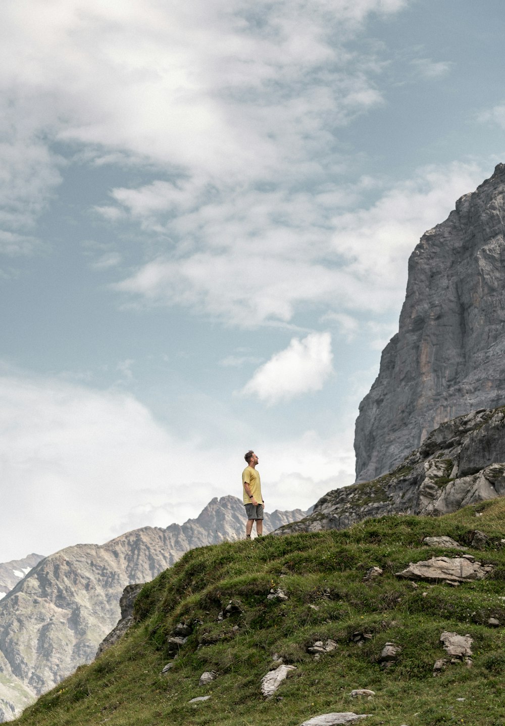 a man standing on top of a lush green hillside