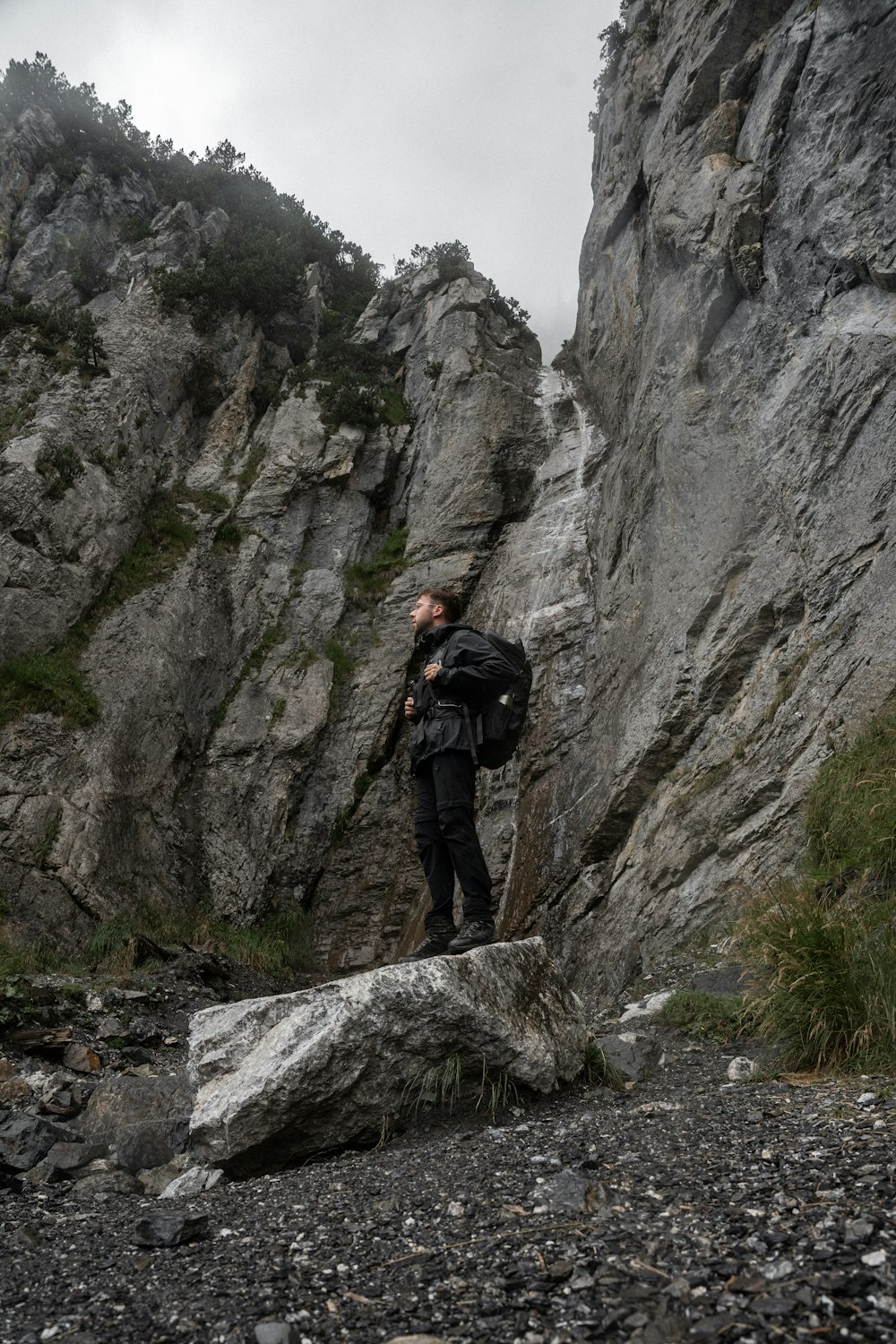 a man with a backpack standing on a rock