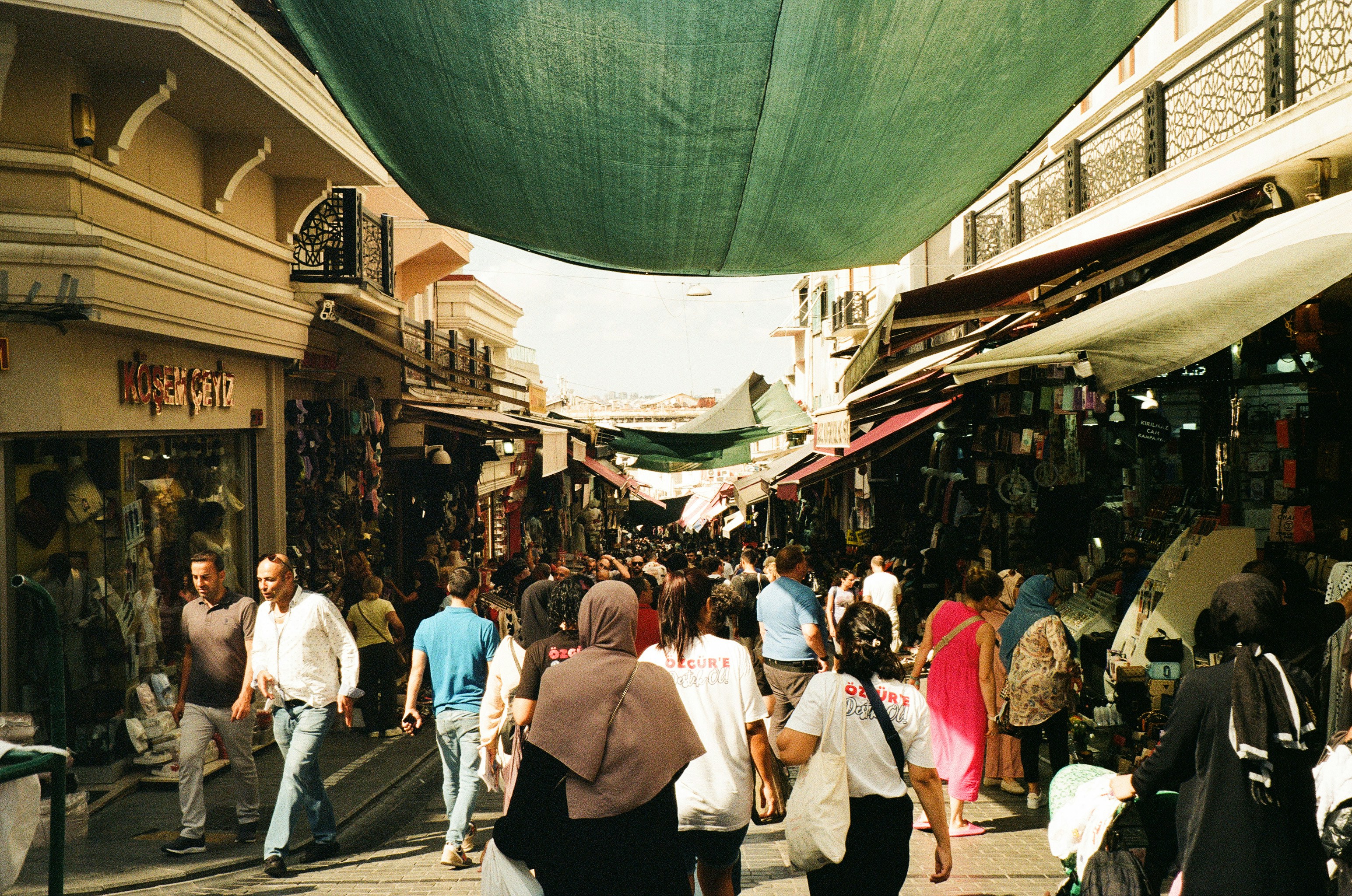 a group of people walking down a street next to shops, Fujifilm 200