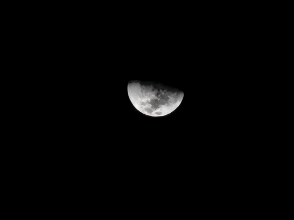 the moon is seen through the dark night sky