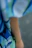 Close-up of a man wearing a vivid, finely crafted t-shirt with a cozy, colorful background.