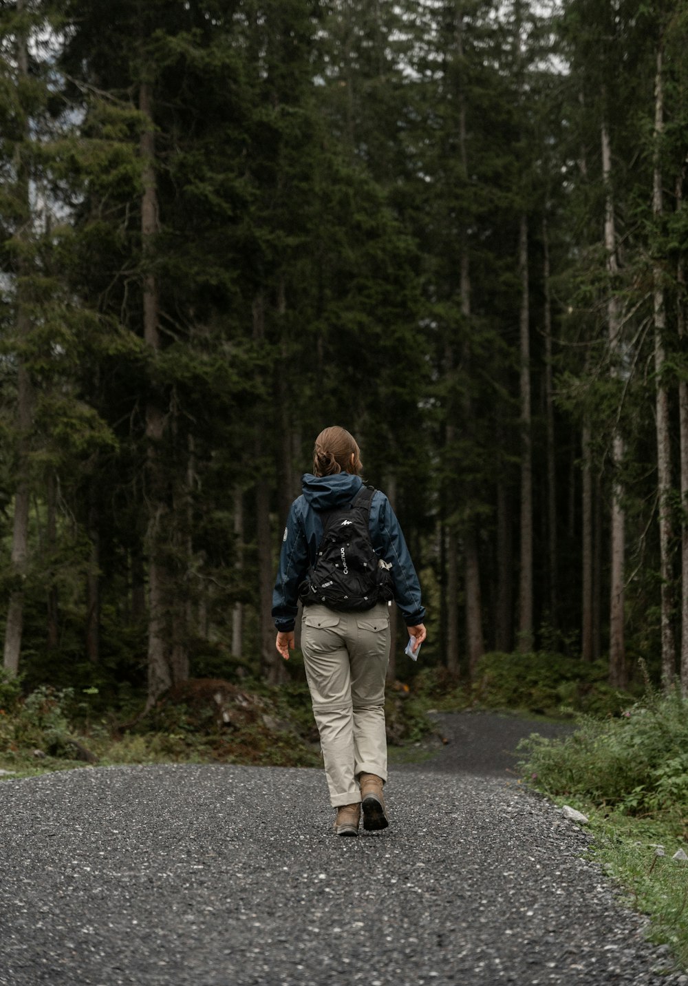 a person walking down a road in the woods