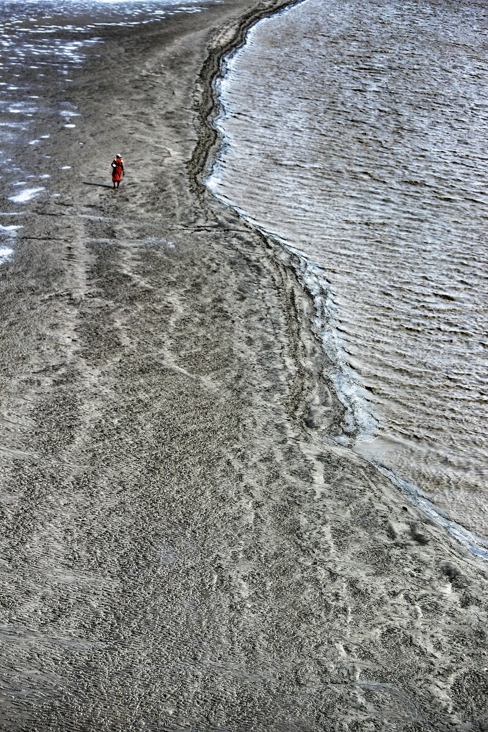 a person walking along a beach next to the ocean