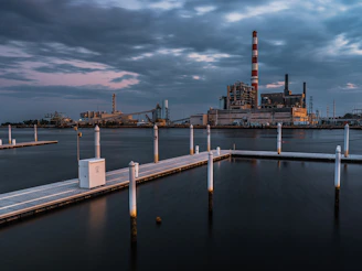 a dock with a factory in the background