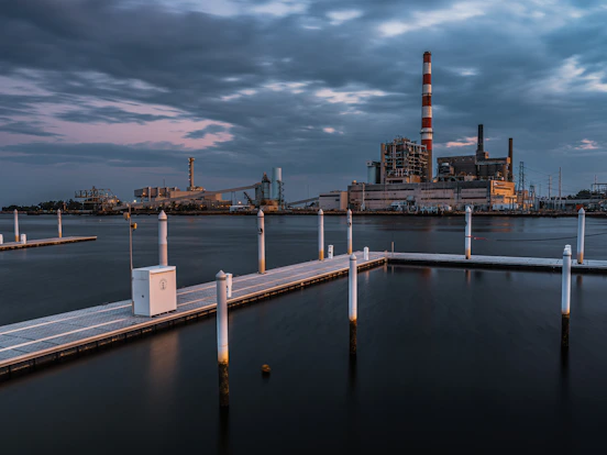 a dock with a factory in the background