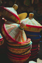 Colorful handwoven baskets stacked neatly in a sunlit corner.