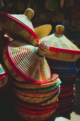 A close-up of colorful weaved Bolga baskets stacked neatly, showcasing their natural fibers and vibrant patterns.
