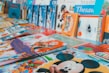 An assortment of colorful children's books arranged on a surface. The books feature popular animated characters and themes, with prominent illustrations on their covers.