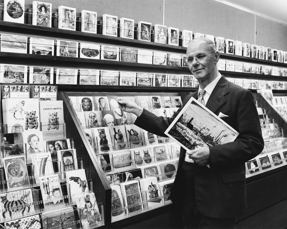 a man in a suit and tie holding a magazine