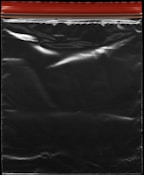 A transparent plastic zipper storage bag with a red and yellow sealing stripe at the top. The bag appears shiny under light, showing reflections and creases in the material.