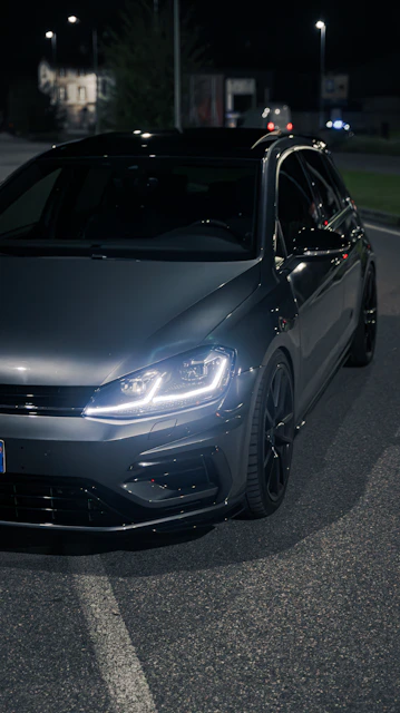 a car parked on the side of the road at night