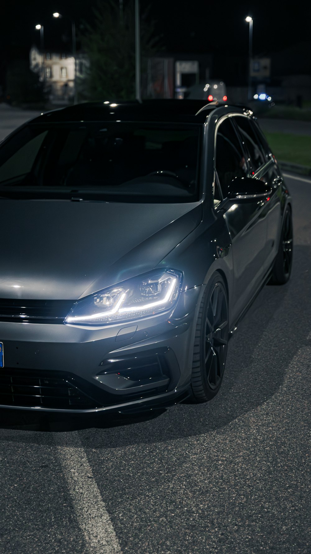 a car parked on the side of the road at night