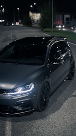 A sleek used car parked beside a glowing loan approval notification on a phone.