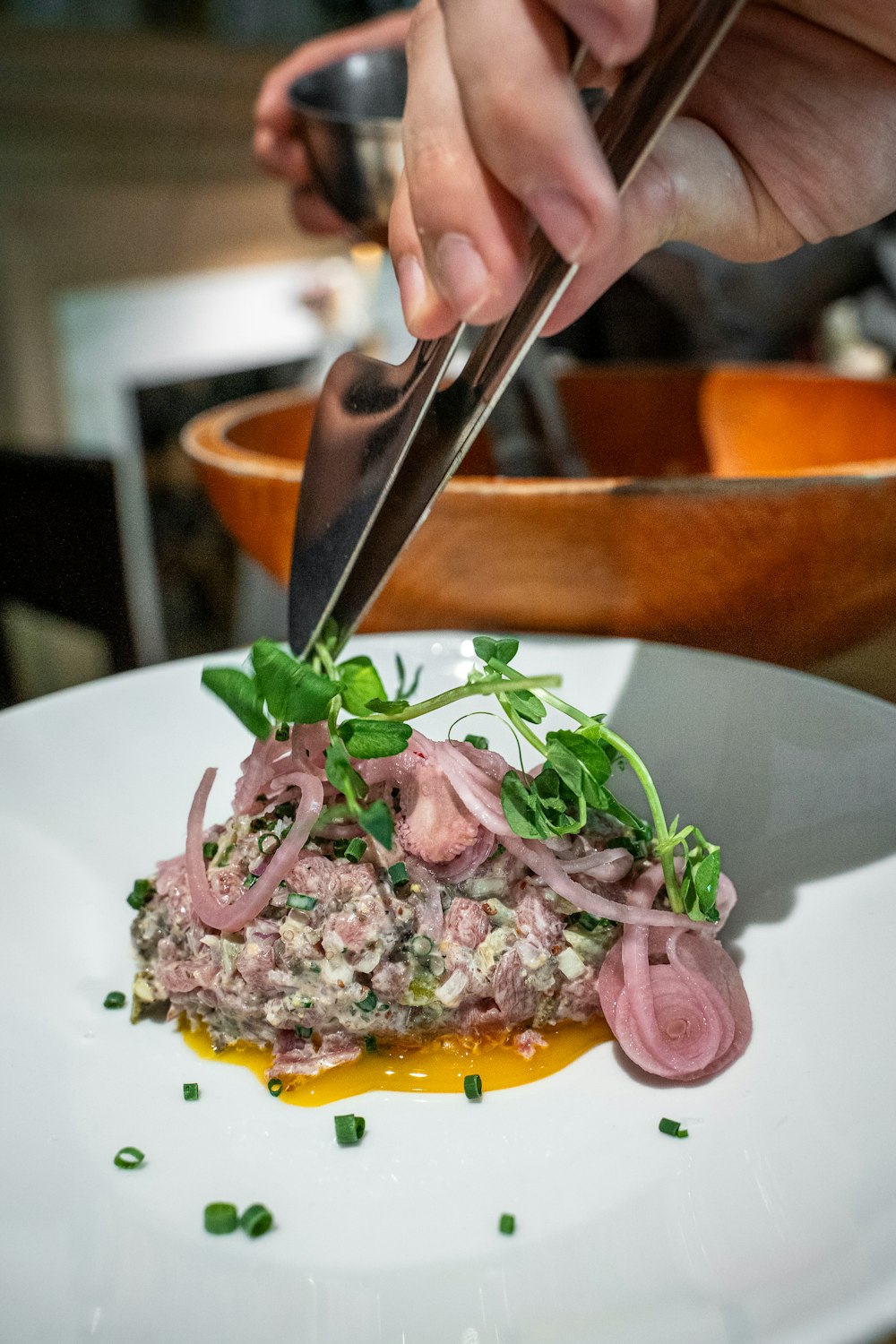 a person cutting a piece of food on a plate