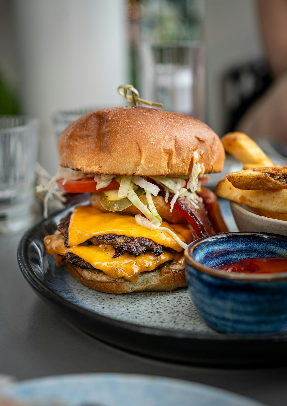um cheeseburger em um prato com batatas fritas ao lado