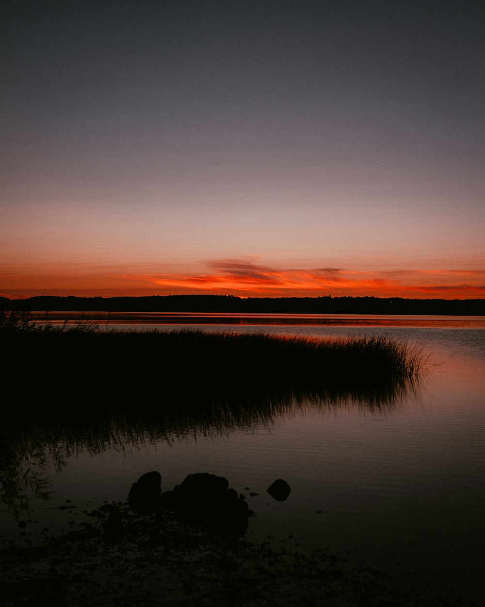 un plan d’eau avec un coucher de soleil en arrière-plan