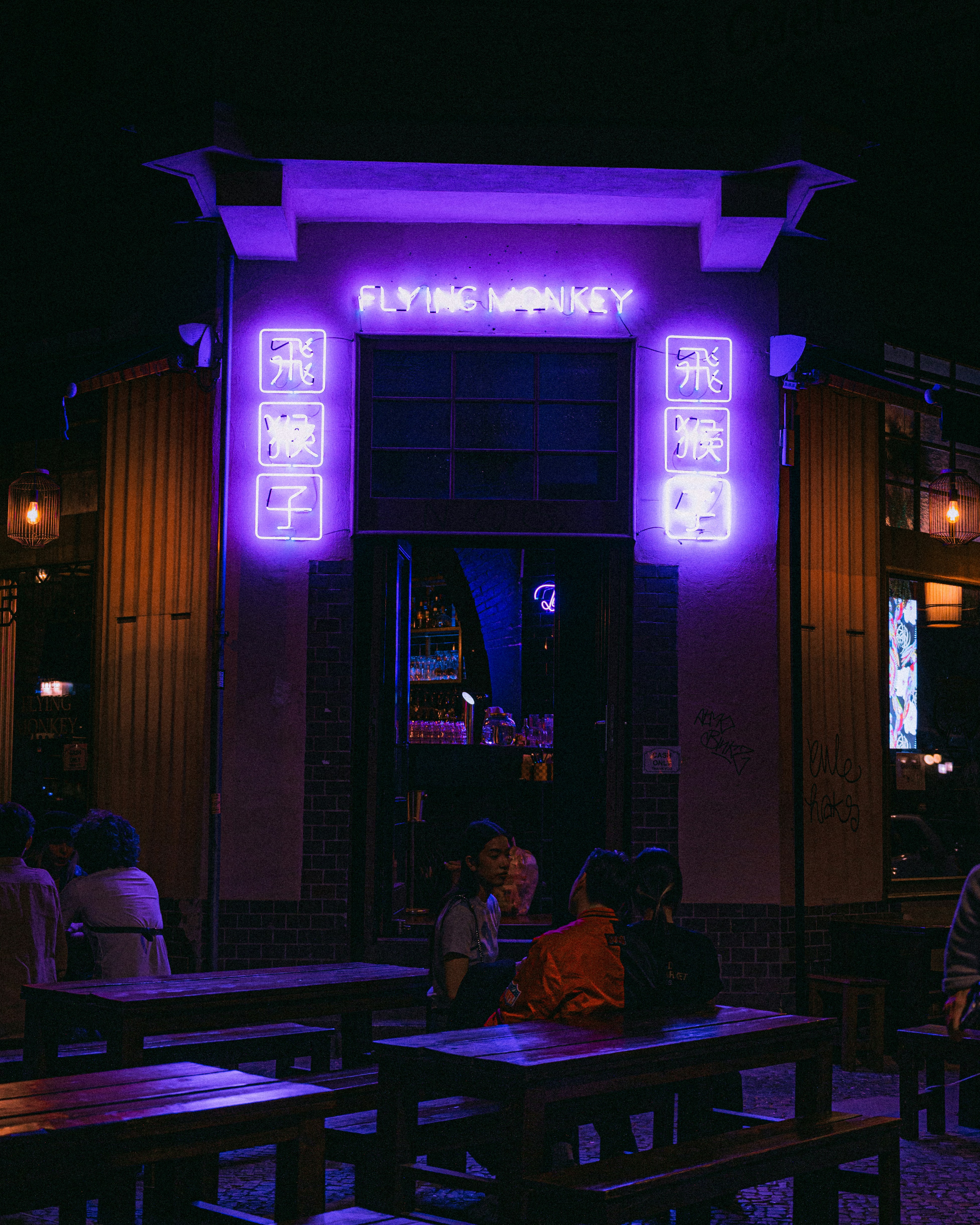 eine Gruppe von Menschen, die an Tischen vor einem Gebäude sitzen