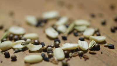 A close-up of moringa leaves and seeds arranged on a wooden table.