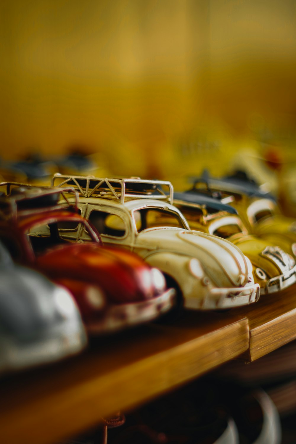a row of toy cars sitting on top of a wooden shelf