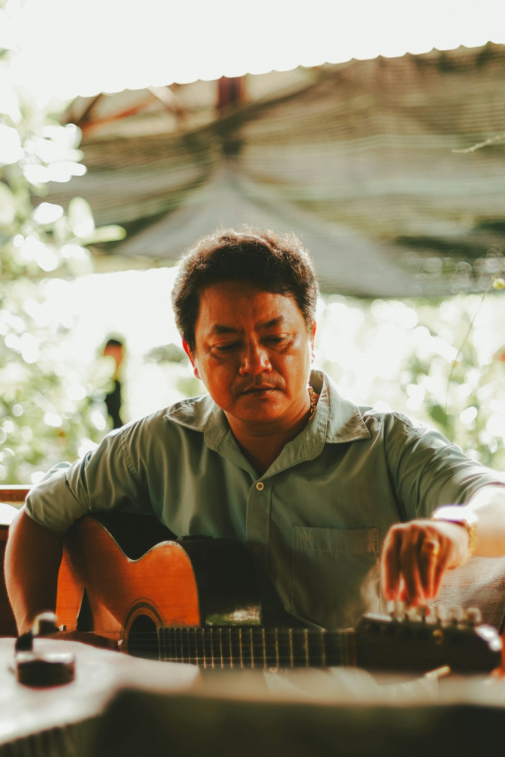 a man sitting down playing a guitar