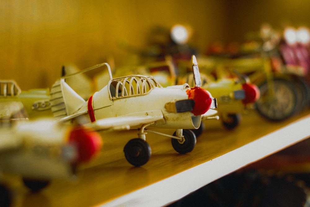 a row of toy airplanes sitting on top of a wooden shelf