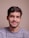 a man with a goatee smiles at the camera