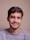 a man with a goatee smiles at the camera