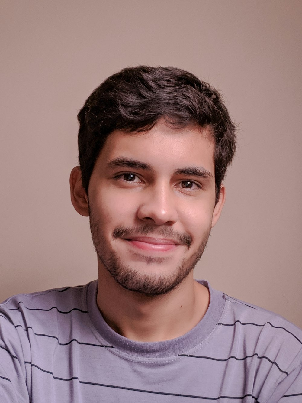 a man with a goatee smiles at the camera