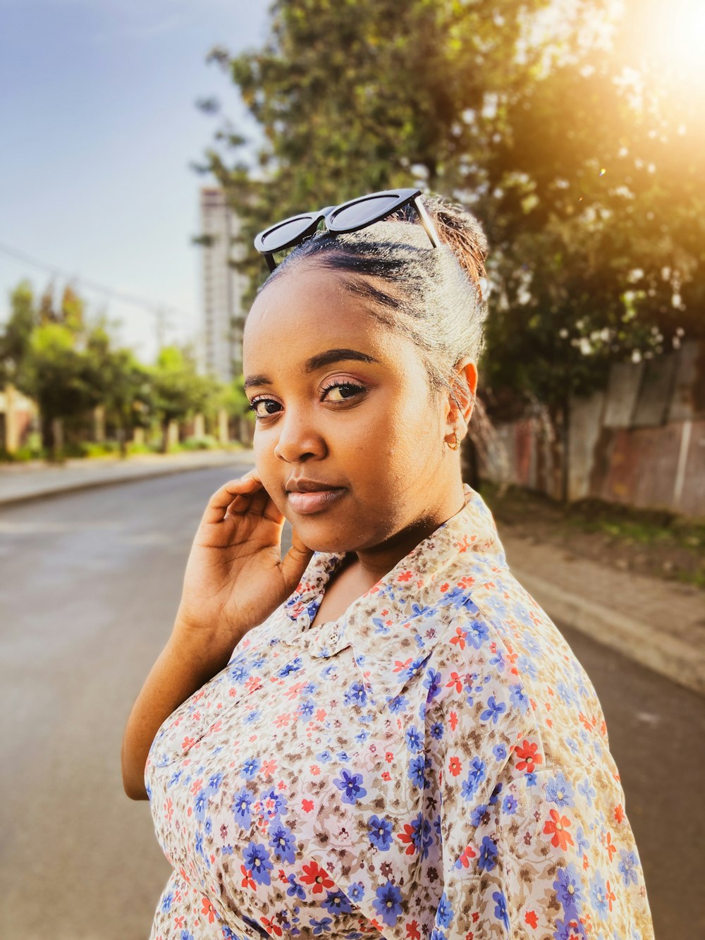 a woman in a floral shirt is talking on a cell phone