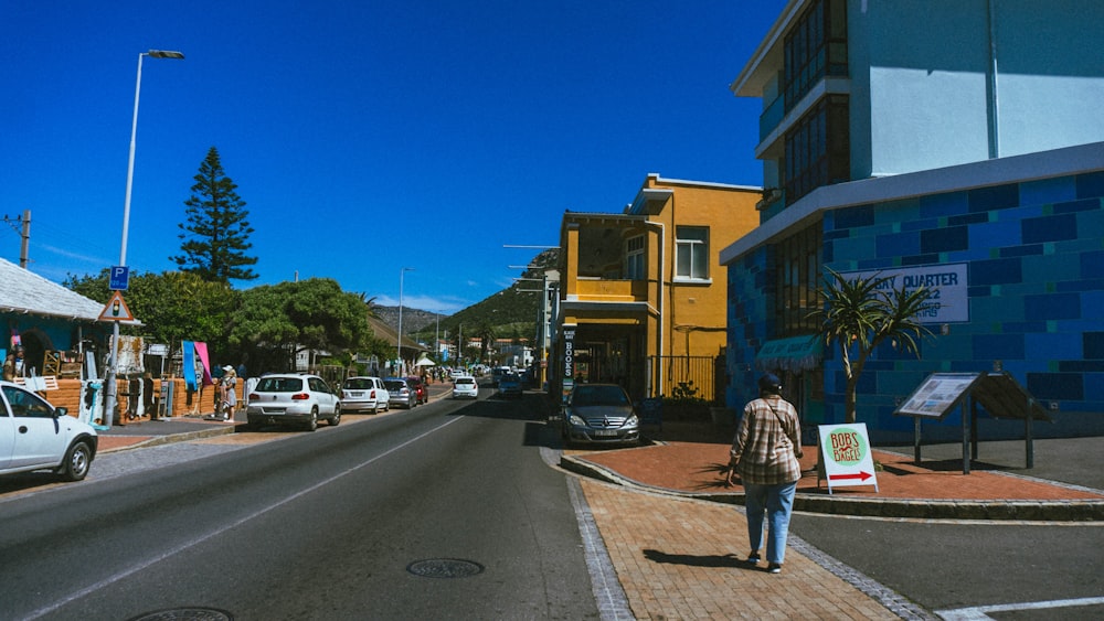 a man walking down a street next to tall buildings