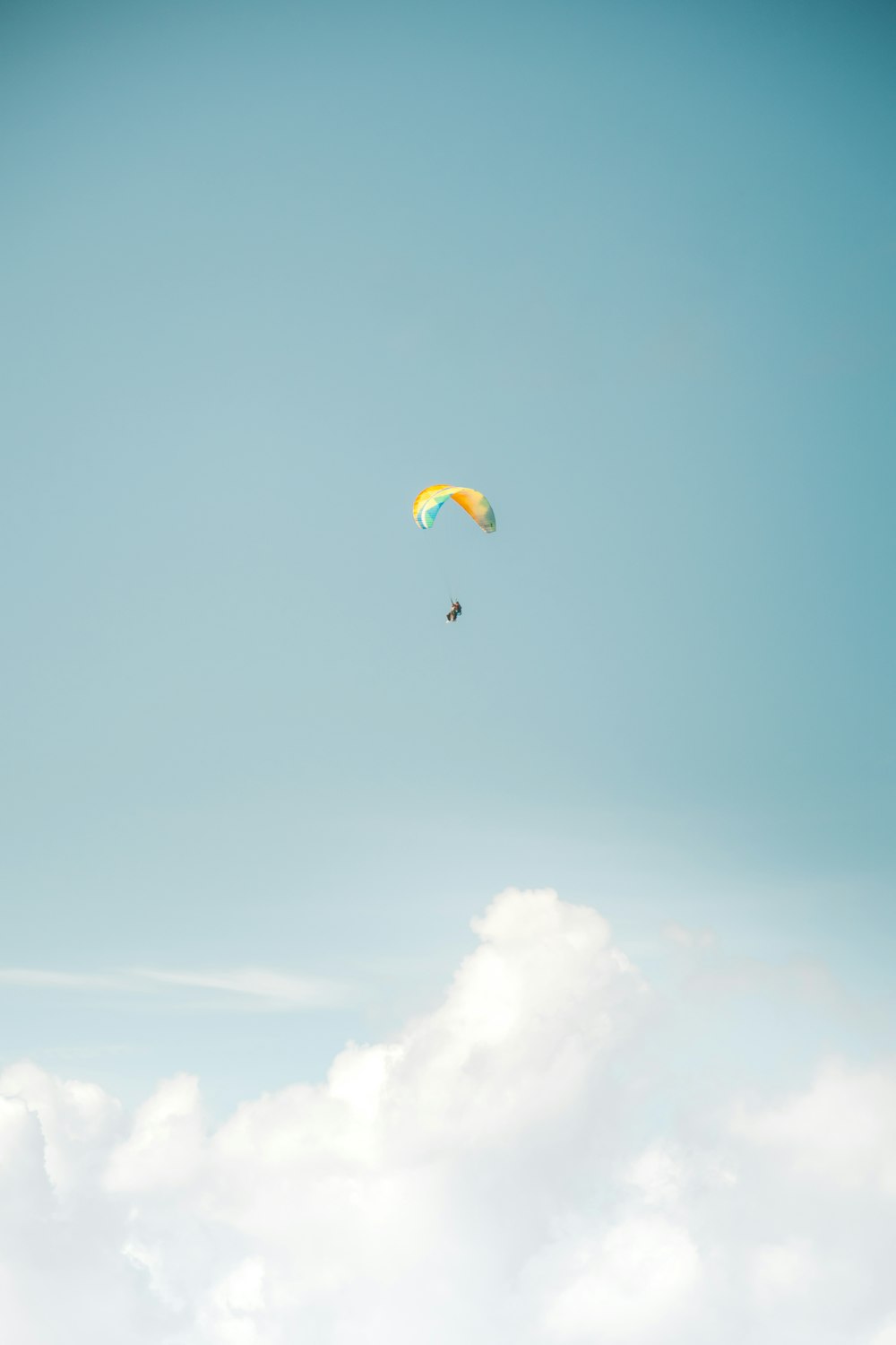 a parasailer is flying high in the sky