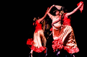 A vibrant group of dancers performing a traditional intercommunity ballet on stage.