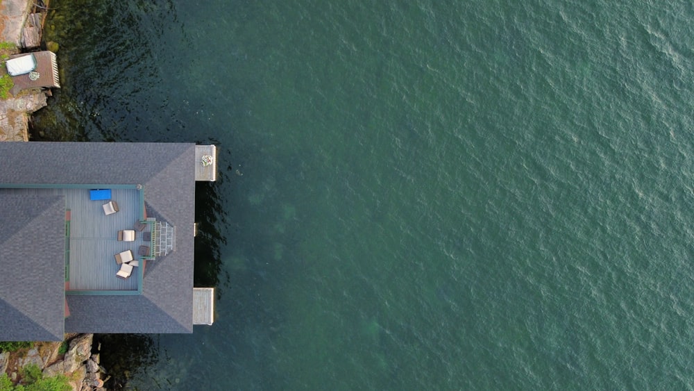 an aerial view of a house next to a body of water