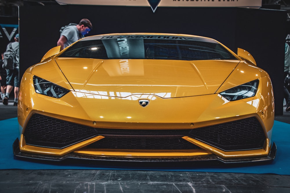 a yellow sports car on display at a car show