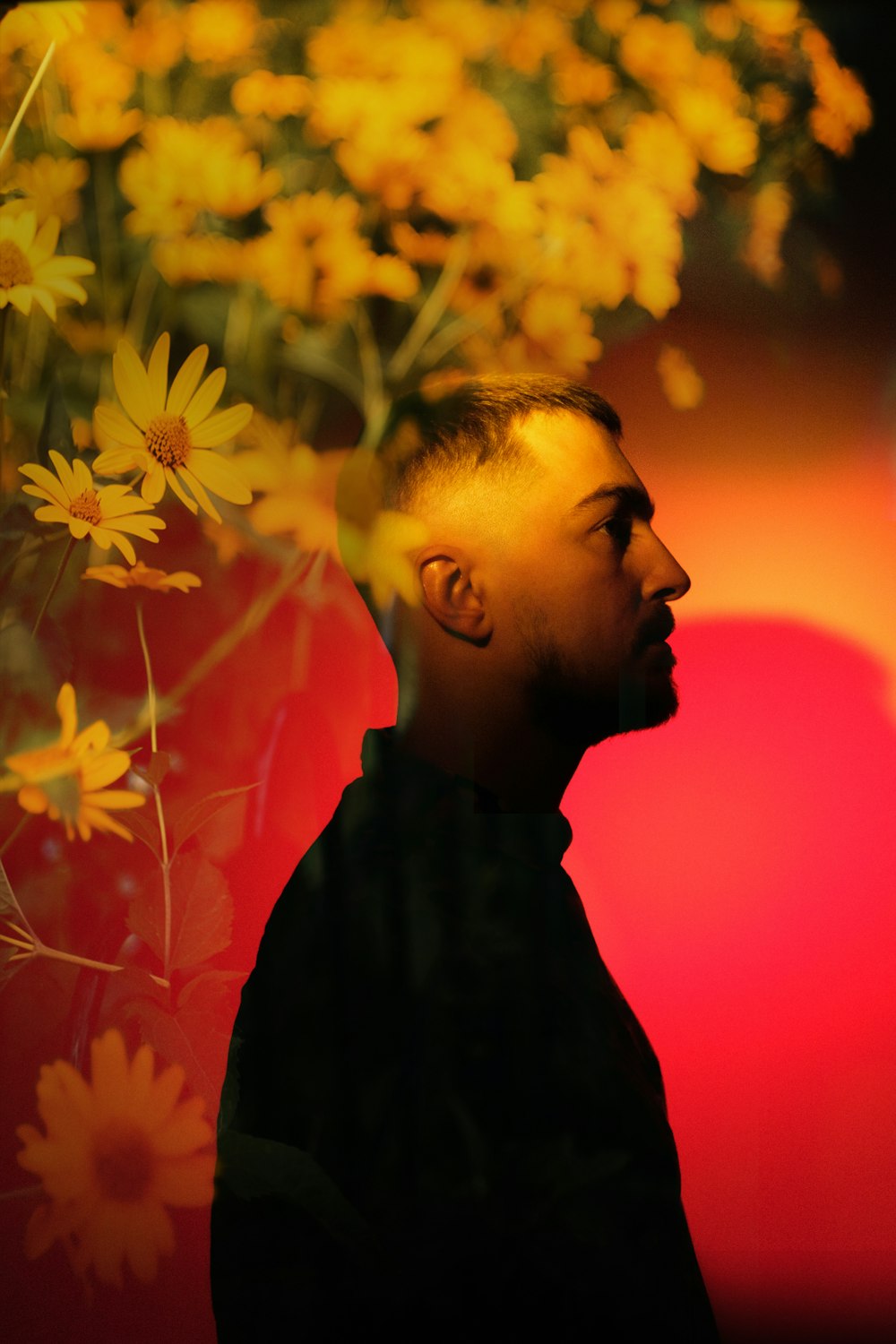 a man standing in front of a bunch of flowers