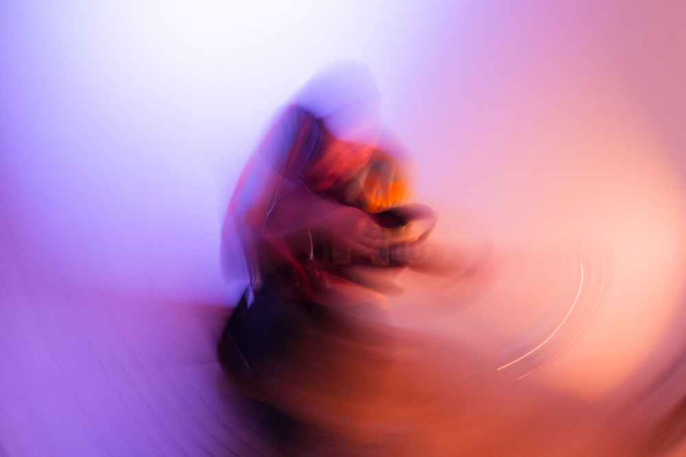 a blurry image of a person holding a cell phone