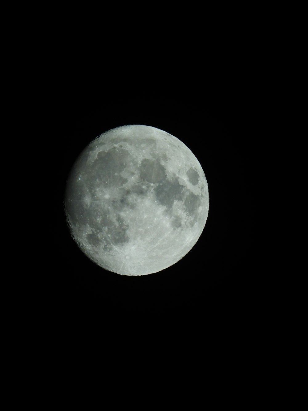 a full moon is seen in the dark sky