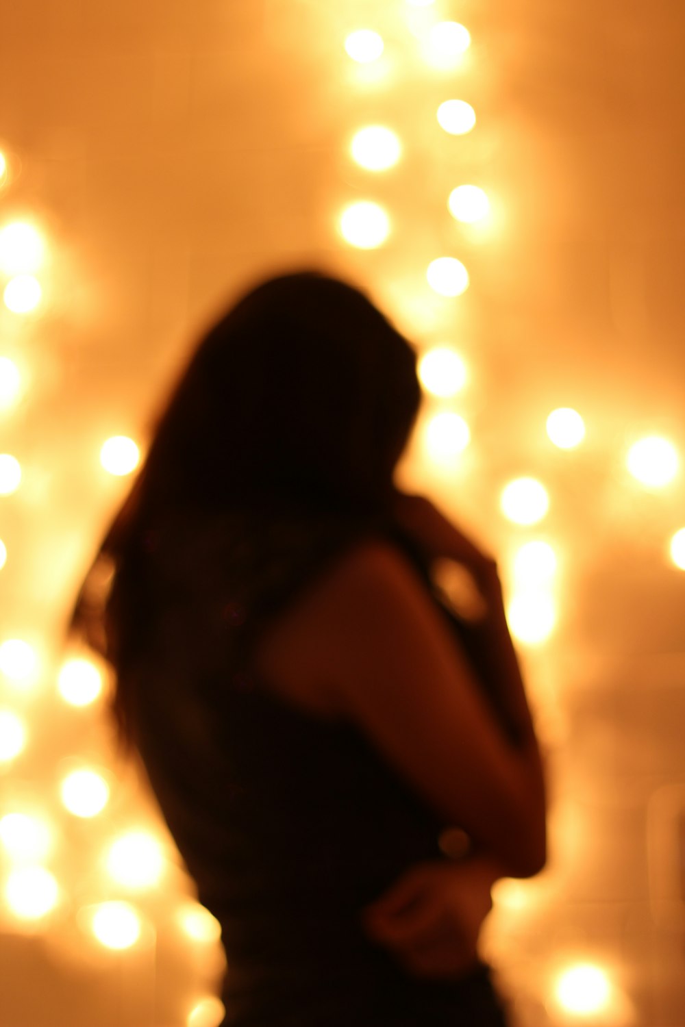 a woman standing in front of a wall covered in lights