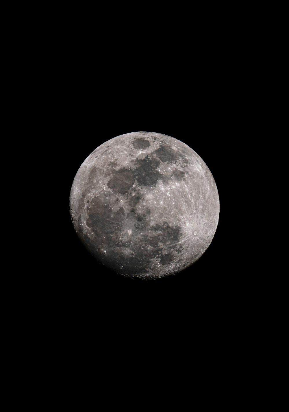 a full moon is seen in the dark sky