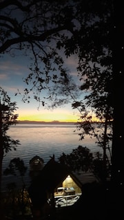 Sunset view over the calm river beside cozy wooden cottages at Haven by the Lake.