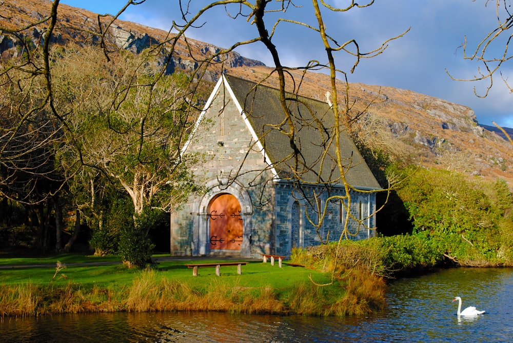 a house with a red door sitting next to a body of water