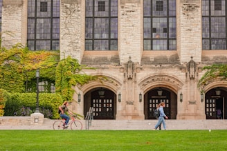 a couple of people that are walking in front of a building