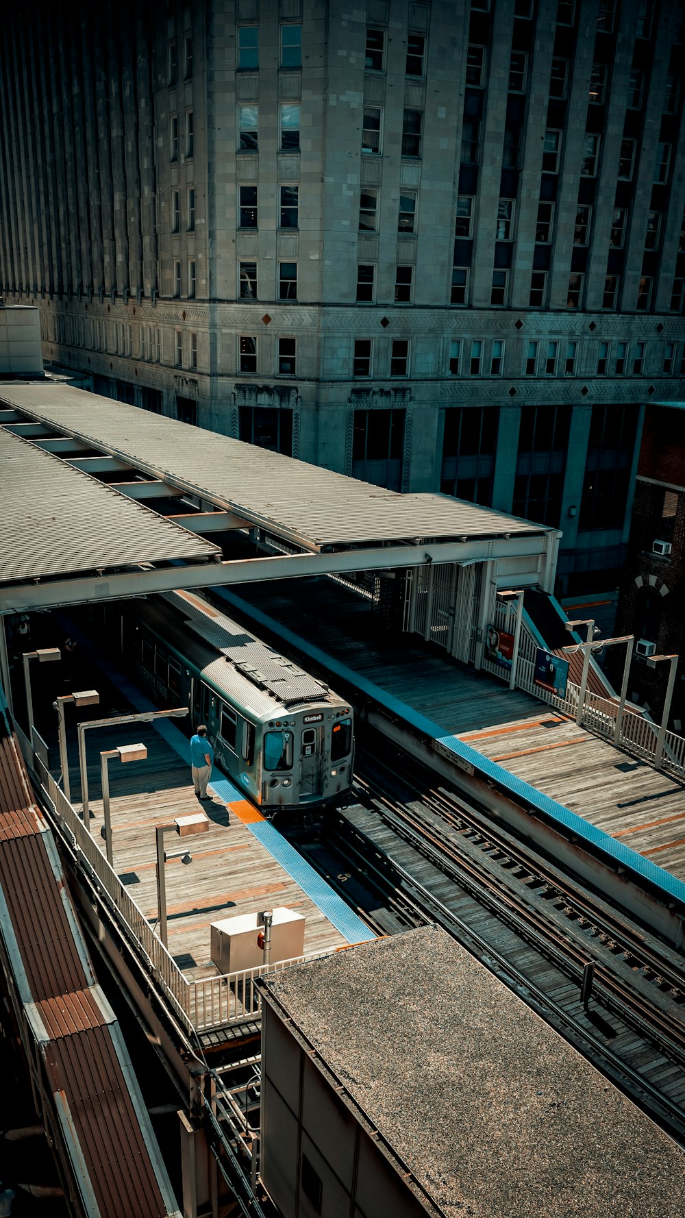 a train traveling through a train station next to tall buildings